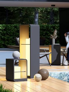 a man sitting on a chair next to a pool with balls and furniture around it