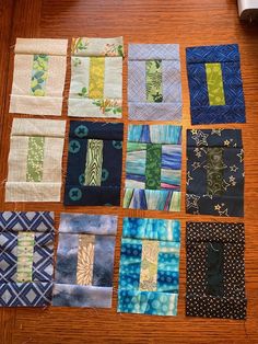 many different types of quilts laid out on a wooden table top with one piece missing