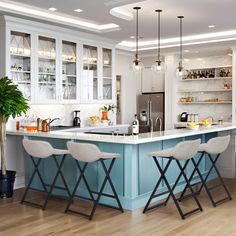 a kitchen with white cabinets and blue island