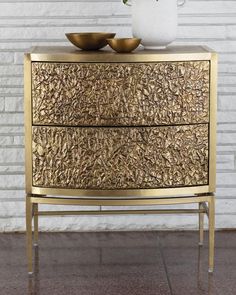 a gold dresser with two bowls on top