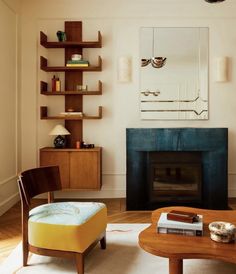 a living room filled with furniture and a fire place next to a wall mounted mirror