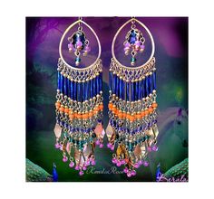 This pair of Exotic Colorful Beaded Boho Chandelier Earrings is made with Cobalt Blue, Bright Orange, Violet, Hot Pink and Emerald Green glass beads and plated metals.  The hoop frames a decorated blue crystal teardrop bead.  The beaded strands flare out into metal dangle charms and pink glass beads.  Available with Posts, Clip-Ons or French Wires. -6" Long x 1 1/2" Wide -0.5 oz. ea. medium If you like this design you may also like these:   https://www.etsy.com/listing/475664219/5-long-colorful- Blue Dangle Chandelier Earrings For Festival, Festival Blue Chandelier Earrings With Colorful Beads, Blue Bohemian Chandelier Earrings For Festival, Handmade Blue Chandelier Earrings For Festival, Blue Bohemian Chandelier Earrings For Party, Handmade Blue Chandelier Earrings For Festive Occasion, Blue Traditional Chandelier Earrings For Festivals, Traditional Blue Chandelier Earrings For Festivals, Blue Bohemian Hoop Earrings For Party