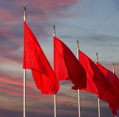 red flags are lined up in the wind