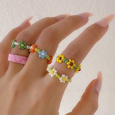 a woman's hand with four rings made out of candy canes and flowers