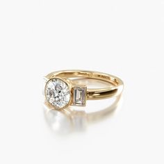 a yellow gold engagement ring with an oval diamond and baguets on the side