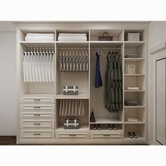 an organized closet with white drawers and clothes hanging on the wall, along with other items