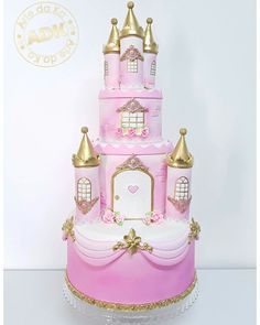 a pink princess castle cake with gold trimmings