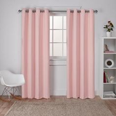 a white chair sitting in front of a window with pink curtains on top of it