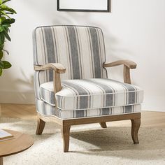 a striped chair sitting on top of a rug next to a potted green plant