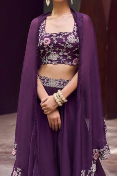 Purple skirt style lehenga with embroidered waistband. Paired with floral hand embroidered blouse and cape with scalloped floral jaal border.
Component: 3
Pattern: Embroidered
Type Of Work: Floral Motifs
Neckline: Square
Sleeve Type: Blouse: Sleeveless
Fabric: Blouse: Tussar; Skirt and Cape: Organza
Color: Purple
Other Details: 
Scalloped hem cape
Asymmetric cape
Occasion: Destination Wedding - Aza Fashions Cape Organza, Asymmetric Cape, Hand Embroidered Blouse, Cape Set, Embroidered Lehenga, Purple Skirt, Blouse Sleeveless, Purple Blouse, Types Of Work