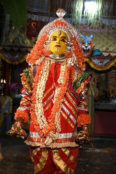 a man dressed in an orange and gold costume