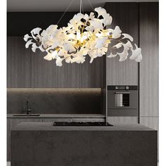 a modern chandelier hanging over a kitchen island with an oven and microwave in the background