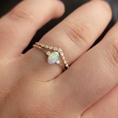 a woman's hand with a ring on it and an opal in the middle