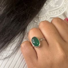 Get ready to make a statement with our Haraye Silver Adjustable Ring, an on-trend gorgeous piece of jewellery that beautifully showcases the vivid forest green hue of the green onyx gemstone. May birthstone is also a popular 2023 trend in gemstone jewellery, thanks to its mesmerizing colour and unique properties. Green onyx gemstone, popular choice among crystal enthusiasts, is a variety of chalcedony stone. Green onyx believed to harness positive communication energy of Mercury. It is also known to be a symbol of renewal and growth, making it a great gift for those who are going through a transformative period in their journey. One UK V size non-adjustable and 2 adjustable rings are available. This beautiful silver ring is handmade with love and care, ensuring that each piece is unique an Fusion Rings With Oval Natural Stones, Fusion Style Oval Rings With Natural Stones, Fusion Style Oval Ring With Natural Stones, Fusion Oval Rings With Natural Stones, May Birthstone Ring With Large Stone, Oval Natural Stone Ring For May Birthstone, Oval Rings With May Birthstone And Natural Stones, Oval Natural Stones Ring For May Birthstone, May Birthstone Oval Rings With Natural Stones