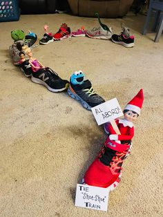 an elf is sitting on top of a pair of running shoes and holding a sign