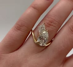 a woman's hand with a yellow gold ring on it and a diamond in the middle