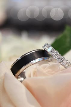 two wedding rings sitting on top of a flower