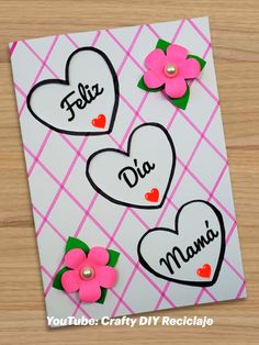 a card with two hearts and flowers on it, which reads feliz dia mama