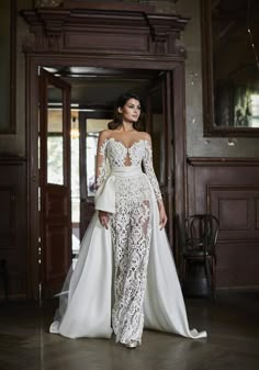 a woman in a wedding dress standing on the floor with her back to the camera