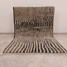 a black and white area rug on the floor in front of a wall with an animal print pattern