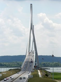 an aerial view of a bridge with cars driving on it and the sky in the background