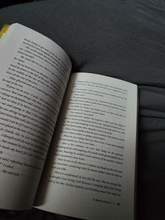 an open book sitting on top of a bed