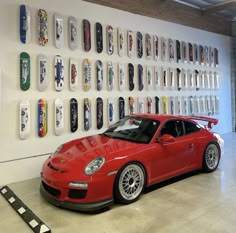 a red sports car parked in front of a display of skateboards on the wall