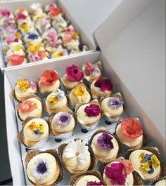 there are many cupcakes in the box and one is decorated with flowers on it