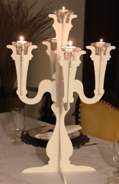 a white candelabra sitting on top of a table next to wine glasses