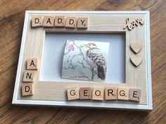 a photo frame with scrabbles and words that spell out daddy and george