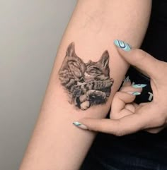 a woman's arm with a cat tattoo on it