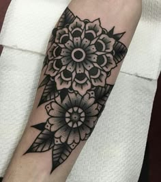 a black and white flower tattoo on the arm