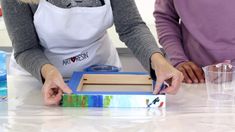 two women in aprons working on an art project