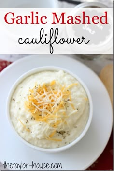 garlic mashed cauliflower in a white bowl with cheese on top