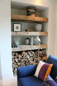 a blue couch sitting next to a pile of firewood