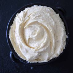 a black bowl filled with whipped cream on top of a table