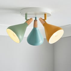 three different colored lamps hanging from the ceiling