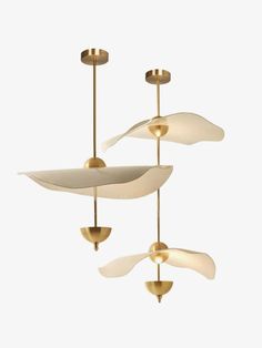 three light fixtures hanging from the ceiling in an art deco style with white and gold accents