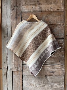 a brown and white blanket hanging on a wooden wall