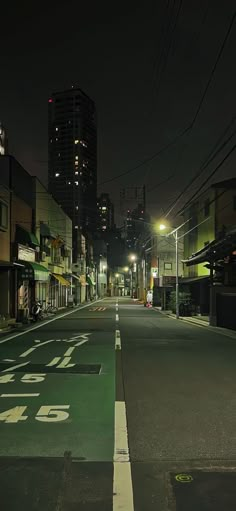 an empty street at night with buildings in the background