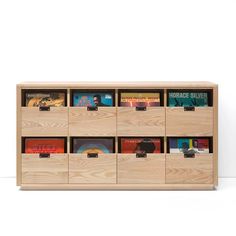 a wooden book shelf filled with books on top of each other and drawers below it