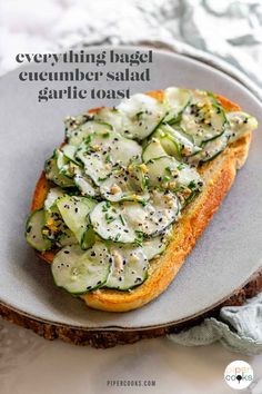 a sandwich with cucumber and black sesame seeds on it sitting on a plate