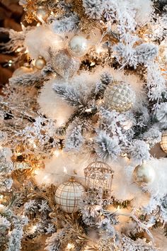 a white christmas tree with gold and silver ornaments