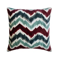 a red, green and blue chevroned pillow on a white background