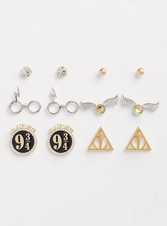 six harry potter pin badges and pins on a white surface, including one with the deathly hall logo