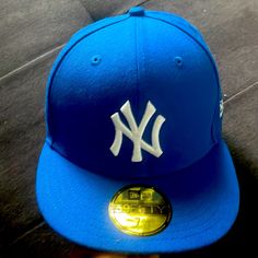 a blue new york yankees hat sitting on the ground