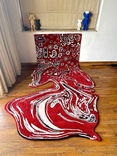 a red and white rug on the floor next to a teddy bear