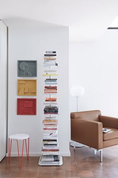 a room with a chair, table and bookshelf on the wall in front of it