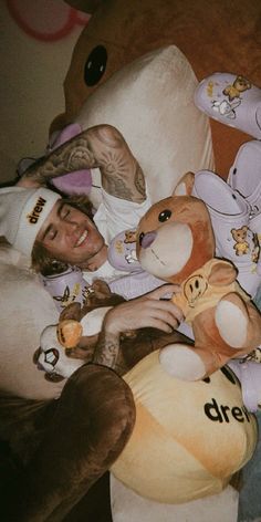 a man laying in bed with stuffed animals