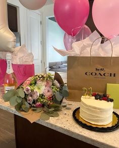 a cake and flowers on a counter with balloons in the background at a bachelor's party